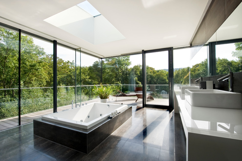 Design ideas for an expansive contemporary ensuite bathroom in Other with open cabinets, a freestanding bath, brown tiles, stone slabs, a pedestal sink and tiled worktops.