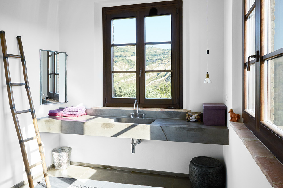 Esempio di una piccola stanza da bagno mediterranea con piastrelle grigie, pareti bianche, ante grigie, lavabo sospeso, top in marmo e pavimento grigio