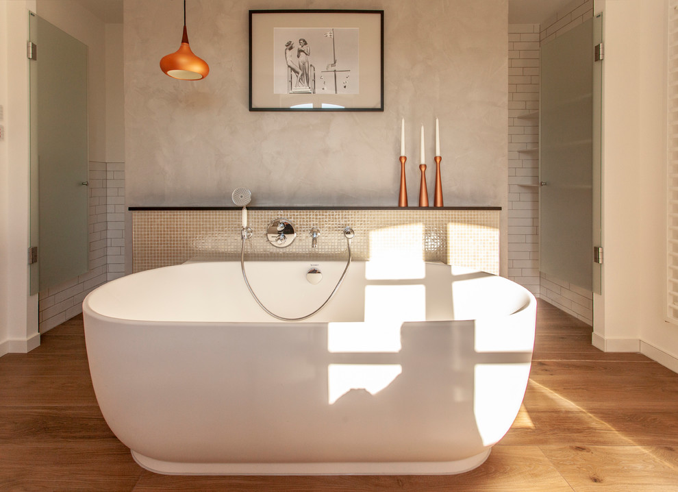 Foto di una grande stanza da bagno contemporanea con vasca freestanding, piastrelle bianche, piastrelle diamantate, pareti grigie e pavimento in legno verniciato