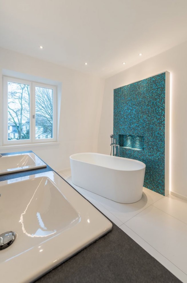 Idéer för mellanstora funkis en-suite badrum, med ett fristående badkar, blå kakel, mosaik, vita väggar, klinkergolv i keramik, ett nedsänkt handfat och vitt golv