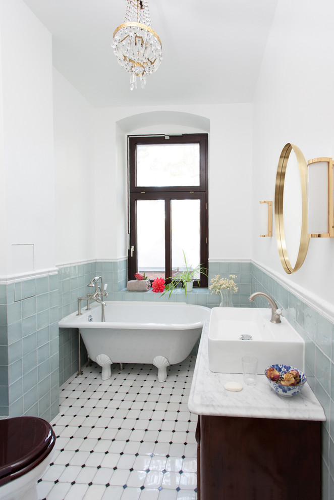 Cette photo montre une petite salle de bain victorienne en bois foncé avec un placard à porte affleurante, une baignoire indépendante, une douche double, WC à poser, un carrelage bleu, un sol en marbre, une vasque, un plan de toilette en marbre, un sol blanc, un plan de toilette blanc, un mur blanc, des carreaux de céramique et une cabine de douche à porte coulissante.