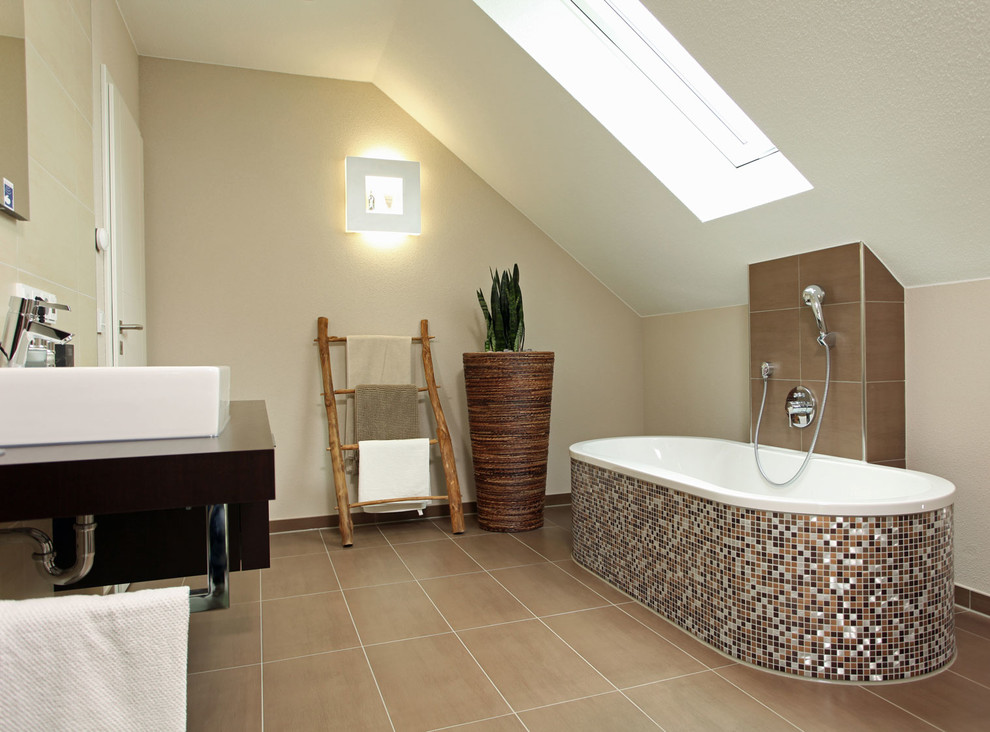 Modernes Badezimmer mit braunen Schränken, freistehender Badewanne, bodengleicher Dusche, braunen Fliesen, beiger Wandfarbe, Terrakottaboden, braunem Boden und weißer Waschtischplatte in Sonstige