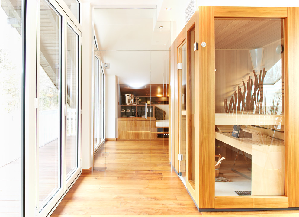 Idee per una grande sauna design con ante lisce, ante in legno scuro, pareti bianche e pavimento in legno massello medio