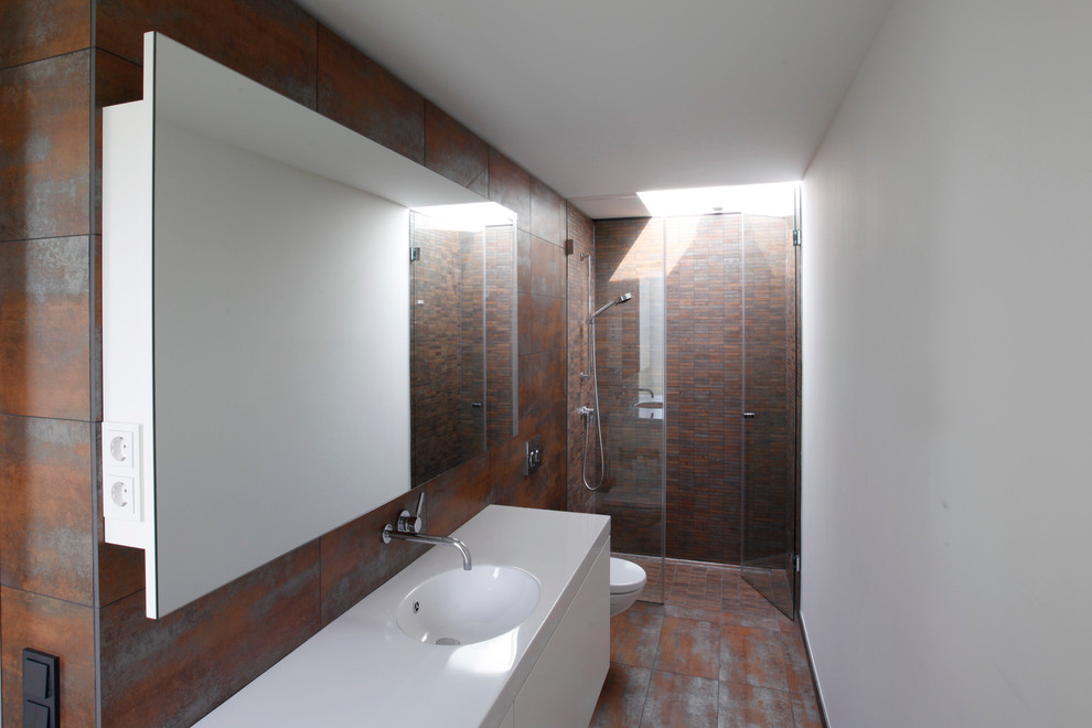 Idéer för ett litet modernt badrum med dusch, med släta luckor, vita skåp, en dusch i en alkov, brun kakel, grå kakel, vita väggar och ett integrerad handfat