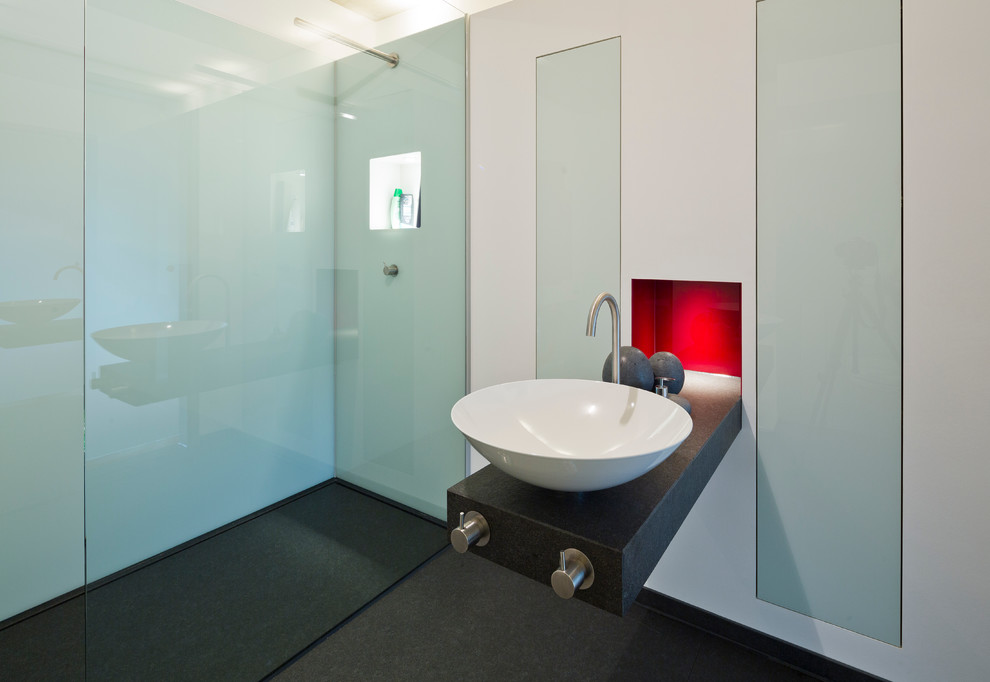 Photo of a medium sized modern shower room bathroom in Hamburg with flat-panel cabinets, white cabinets, a built-in bath, a built-in shower, grey tiles, ceramic tiles, white walls, marble flooring, a vessel sink and granite worktops.