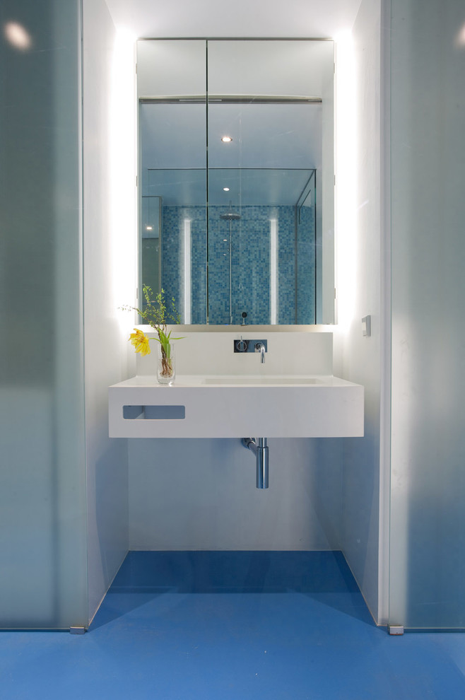 На фото: ванная комната в современном стиле с подвесной раковиной, белыми стенами и зеркалом с подсветкой с