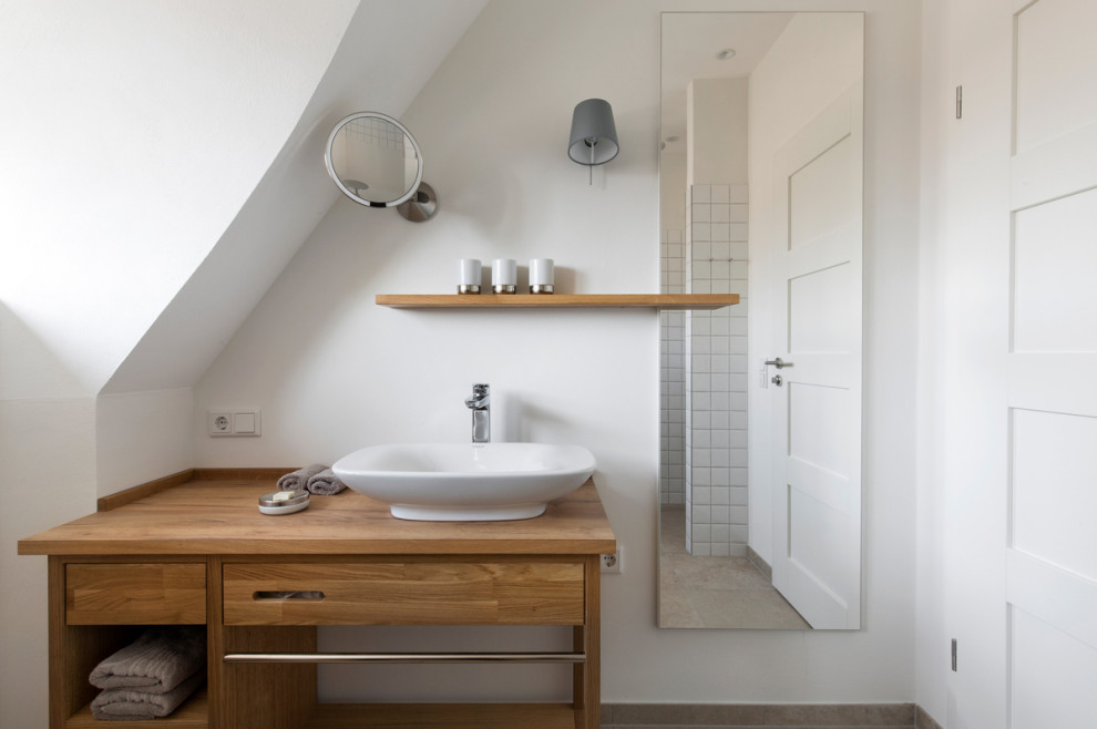 Immagine di una stanza da bagno country con ante in legno bruno, doccia aperta, pareti bianche, un lavabo e mobile bagno incassato