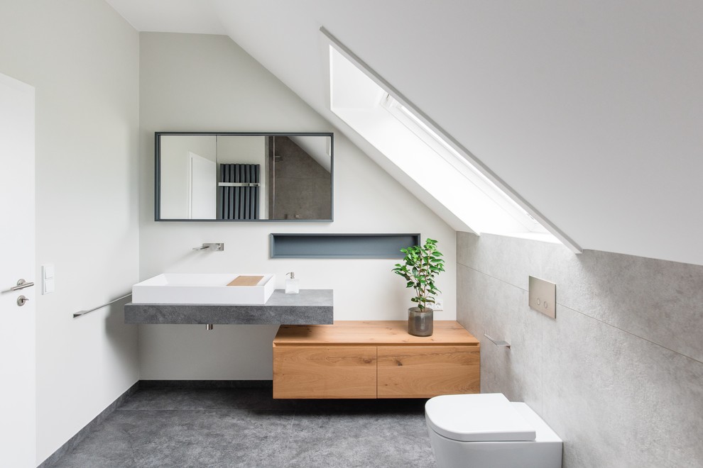 Cette photo montre une salle d'eau tendance en bois clair de taille moyenne avec une douche à l'italienne, un mur blanc, un placard à porte plane, WC suspendus, un carrelage beige, des carreaux de béton, carreaux de ciment au sol, une vasque et un sol gris.