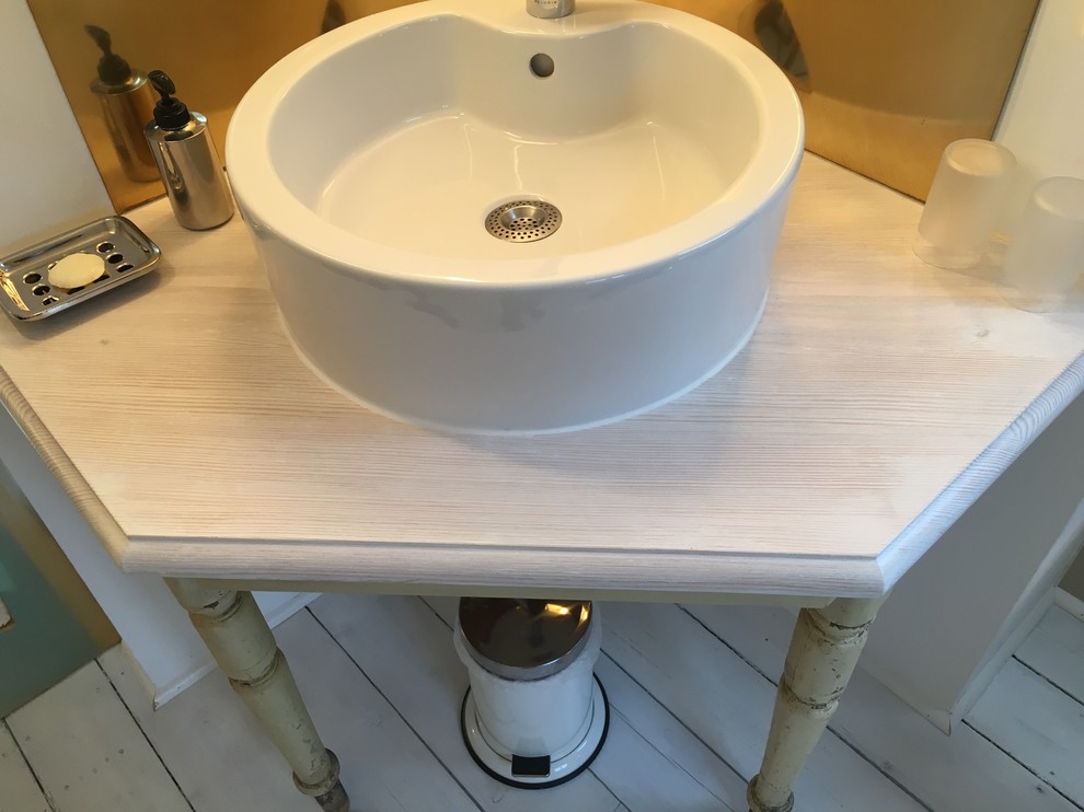 Ejemplo de cuarto de baño de estilo de casa de campo con suelo de madera clara, lavabo sobreencimera y encimera de madera