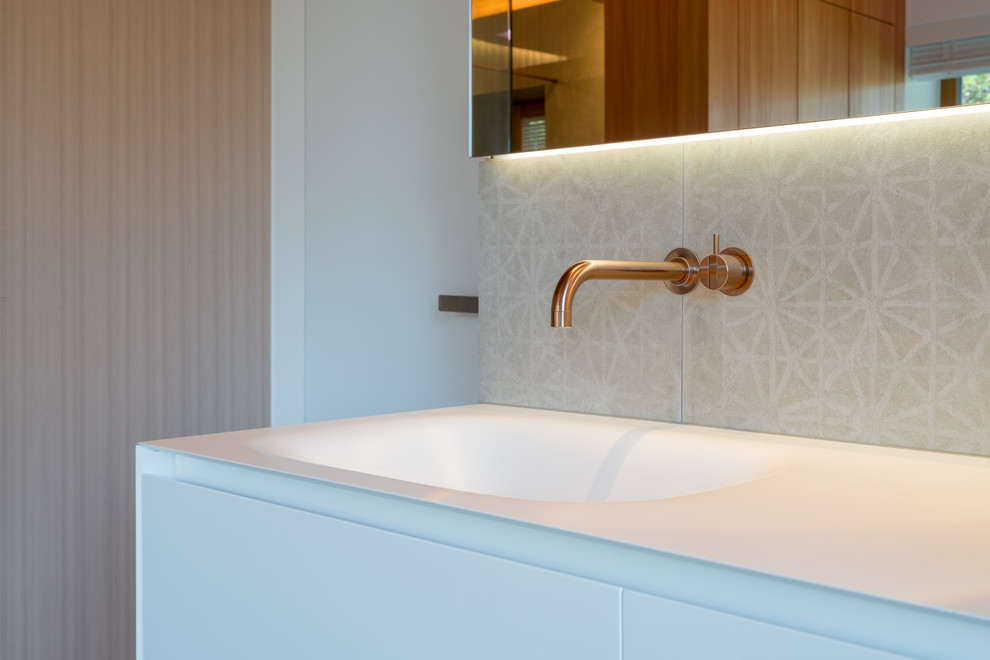 Mittelgroßes Modernes Badezimmer En Suite mit freistehender Badewanne, weißer Wandfarbe, integriertem Waschbecken, Mineralwerkstoff-Waschtisch, grauem Boden und weißer Waschtischplatte in München