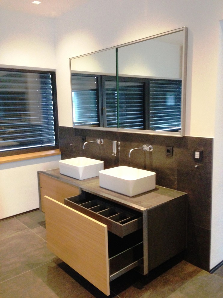 Photo of a contemporary bathroom in Nuremberg with light wood cabinets and tiled worktops.