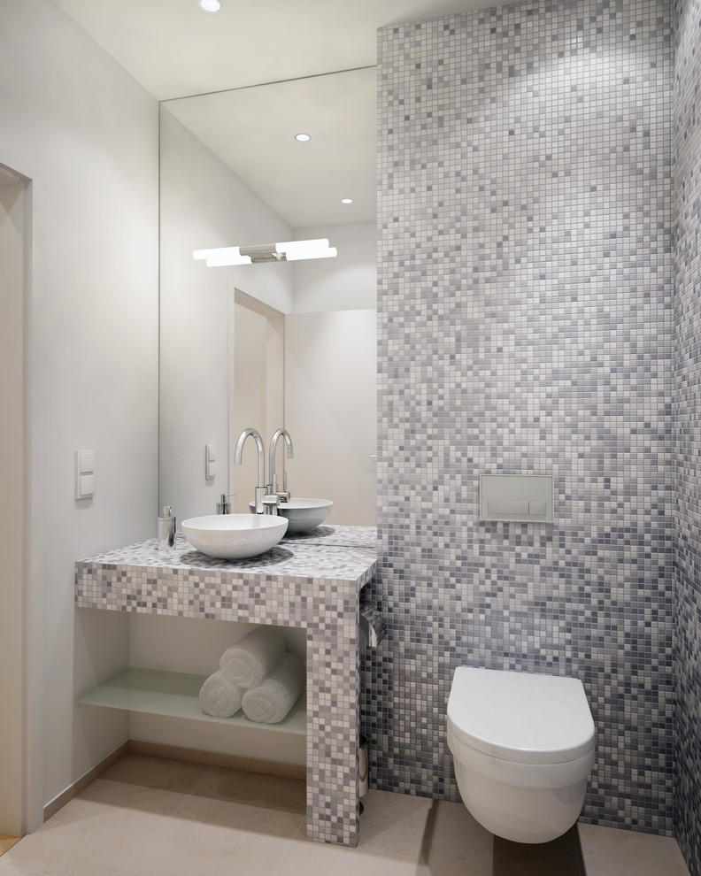 Kleines Modernes Badezimmer mit weißen Schränken, Wandtoilette, Kalkstein, Aufsatzwaschbecken, gefliestem Waschtisch und beigem Boden in München