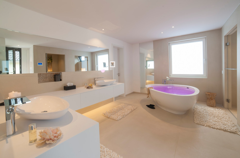 Inspiration for an expansive modern ensuite bathroom in Cologne with flat-panel cabinets, white cabinets, a freestanding bath, a built-in shower, beige tiles, ceramic tiles, beige walls, porcelain flooring, solid surface worktops, beige floors, a hinged door, white worktops and a vessel sink.