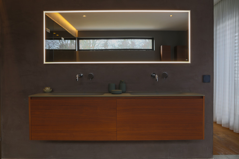 На фото: большая главная ванная комната в стиле модернизм с плоскими фасадами, темными деревянными фасадами, накладной ванной, душем без бортиков, инсталляцией, серой плиткой, каменной плиткой, серыми стенами, полом из цементной плитки, монолитной раковиной, стеклянной столешницей, бежевым полом, открытым душем, зеленой столешницей, сиденьем для душа, тумбой под две раковины, подвесной тумбой, многоуровневым потолком и панелями на стенах