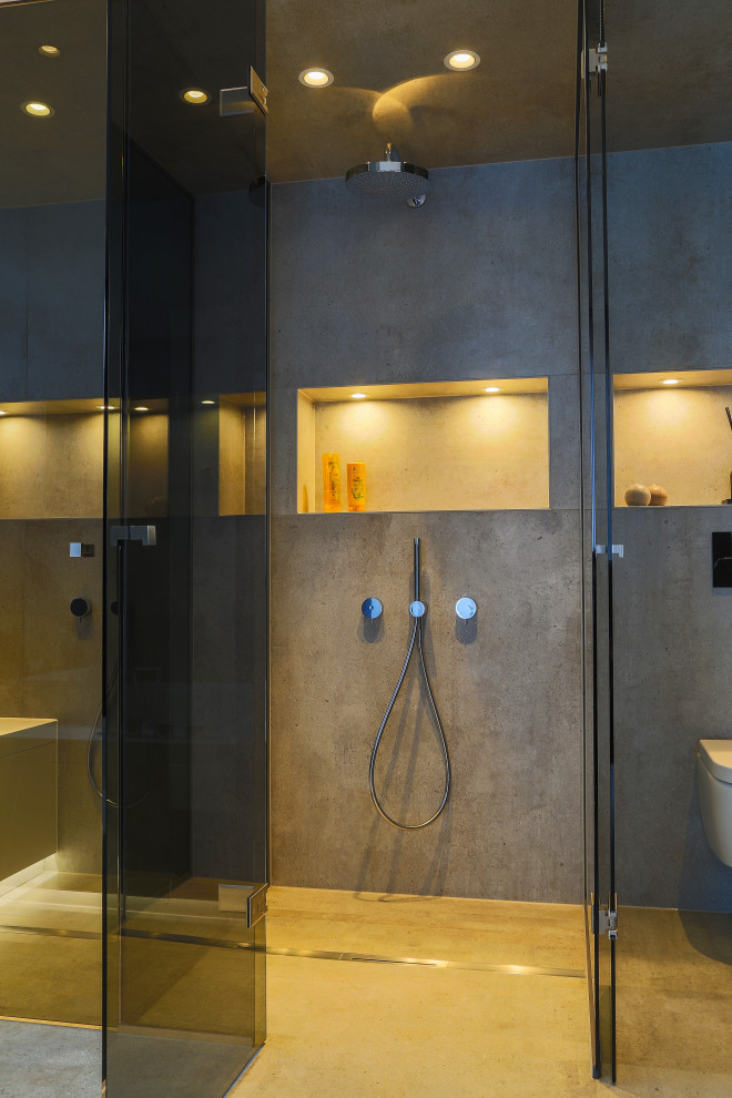 Источник вдохновения для домашнего уюта: большая главная ванная комната в стиле модернизм с плоскими фасадами, темными деревянными фасадами, накладной ванной, душем без бортиков, инсталляцией, серой плиткой, каменной плиткой, серыми стенами, полом из цементной плитки, монолитной раковиной, стеклянной столешницей, бежевым полом, открытым душем, зеленой столешницей, сиденьем для душа, тумбой под две раковины, подвесной тумбой, многоуровневым потолком и панелями на стенах