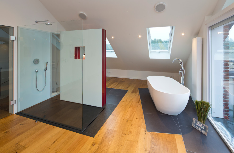 На фото: огромная главная ванная комната в современном стиле с отдельно стоящей ванной, открытым душем, стеклянной плиткой, белыми стенами и паркетным полом среднего тона