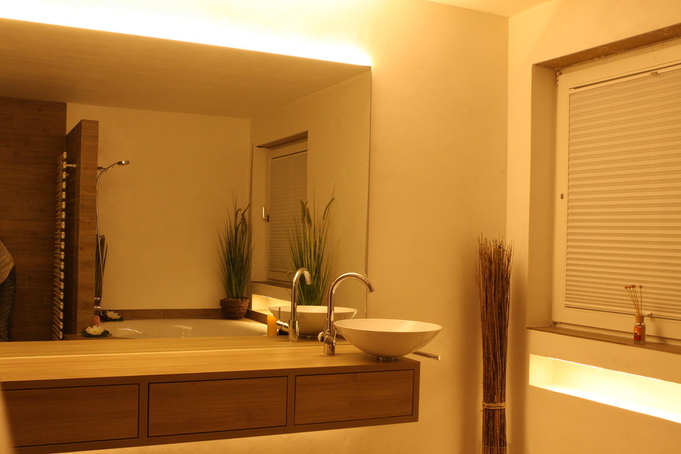 Inspiration pour une grande salle de bain principale design en bois brun avec un placard à porte plane, une baignoire posée, un mur blanc, un sol en bois brun et un plan de toilette en acier inoxydable.