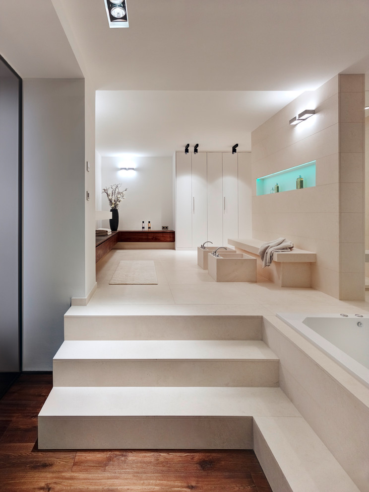 Cette image montre une grande salle de bain principale design en bois foncé avec un placard à porte plane, une baignoire posée, un carrelage beige, des carreaux de béton, un mur blanc, carreaux de ciment au sol et un sol beige.