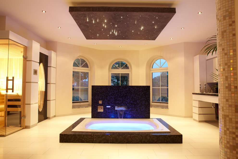 На фото: большая главная ванная комната в современном стиле с накладной ванной, белыми стенами, плоскими фасадами, белыми фасадами, бежевой плиткой и полом из известняка