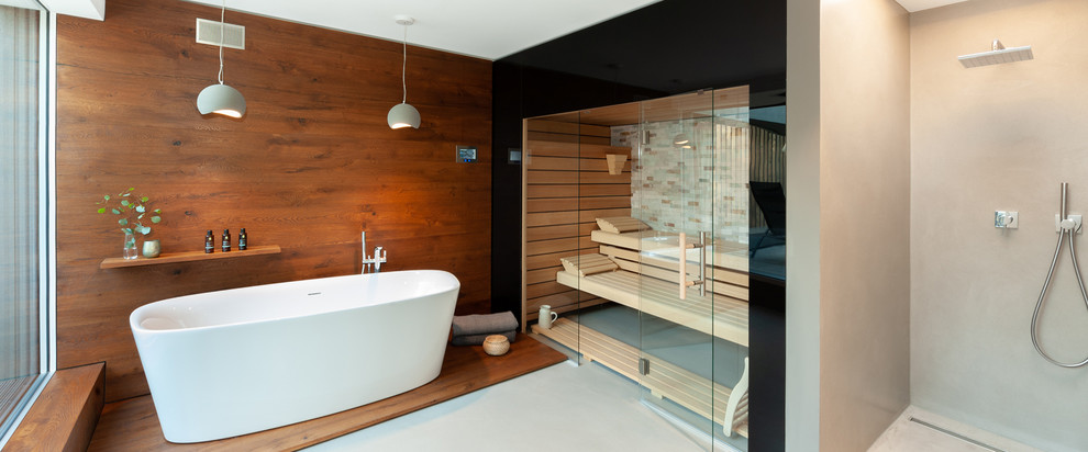 Immagine di una grande sauna minimal con ante lisce, ante in legno bruno, vasca freestanding, doccia a filo pavimento, pareti grigie, pavimento grigio, doccia aperta e top grigio