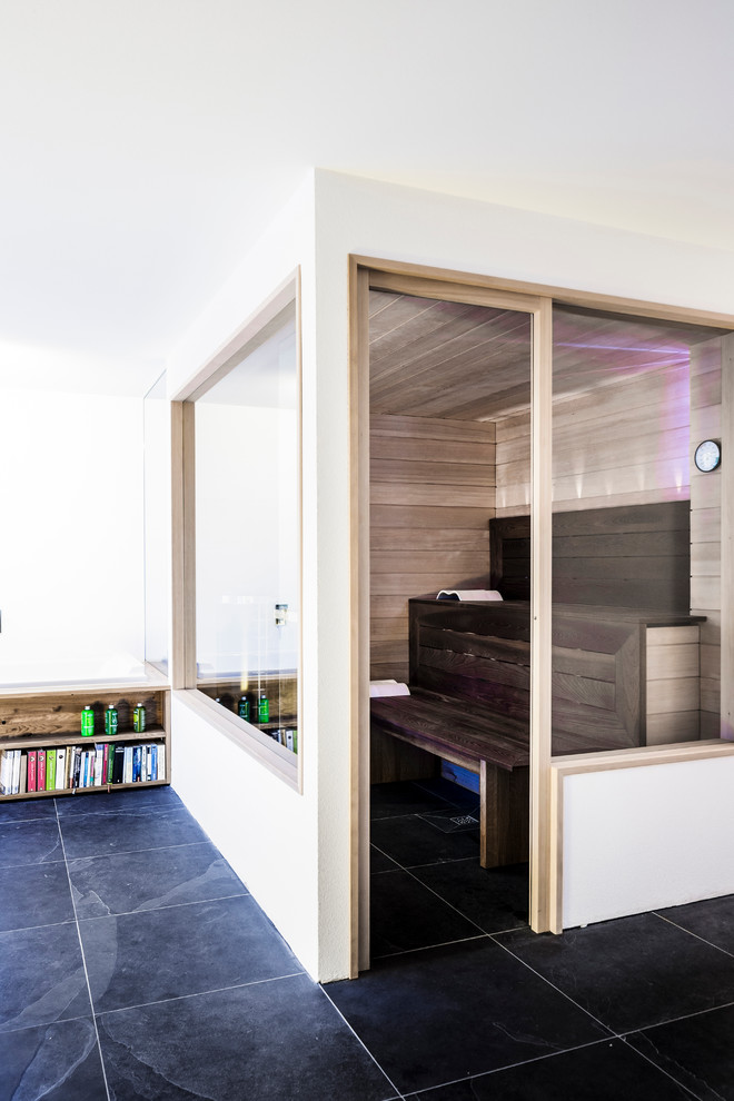 Foto di una sauna minimal di medie dimensioni con piastrelle nere, pareti bianche e pavimento in ardesia