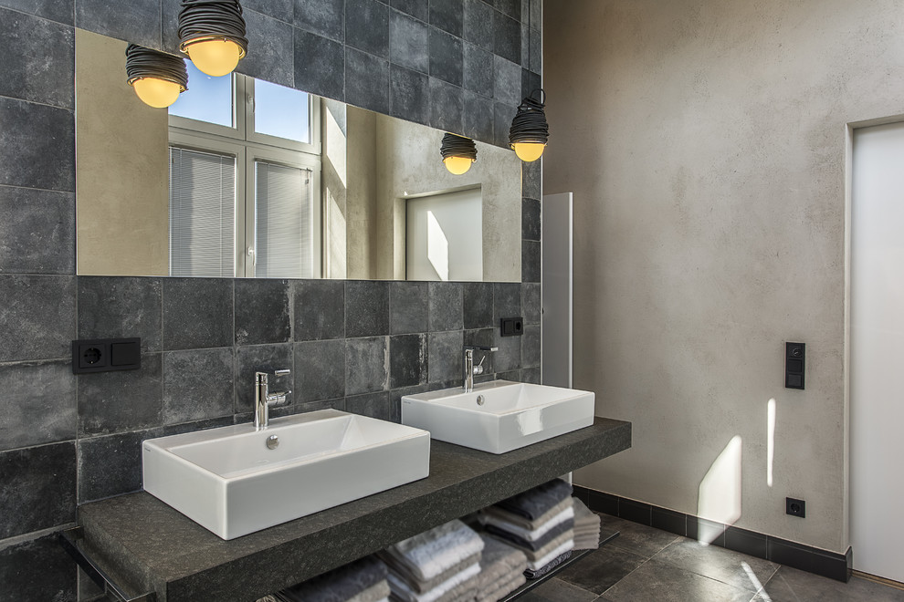 На фото: большая главная ванная комната в стиле лофт с открытым душем, серыми стенами, бетонным полом, настольной раковиной и столешницей из гранита с