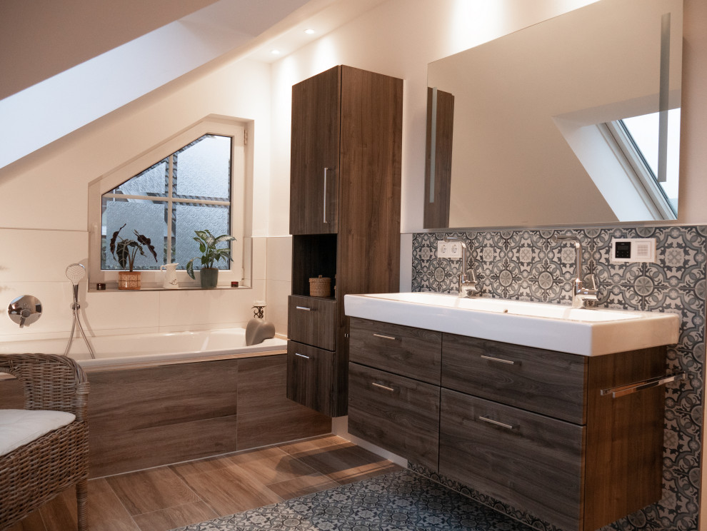 Medium sized contemporary ensuite bathroom in Frankfurt with flat-panel cabinets, medium wood cabinets, a built-in bath, blue tiles, grey tiles, white tiles, white walls, an integrated sink, white worktops, double sinks and a floating vanity unit.
