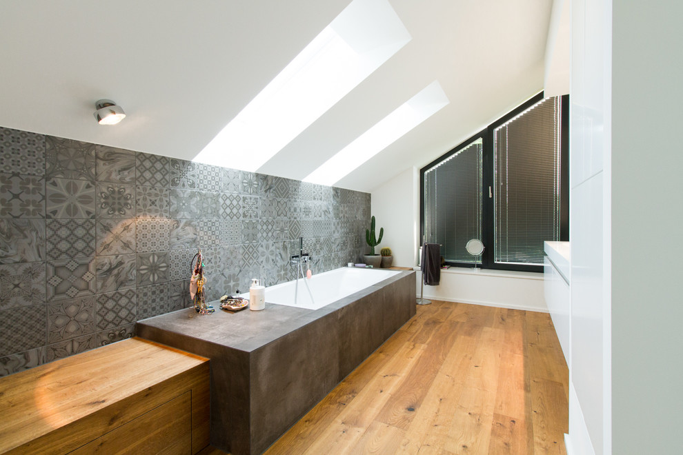 Idéer för mellanstora funkis badrum med dusch, med släta luckor, vita skåp, ett platsbyggt badkar, grå kakel, keramikplattor, vita väggar, mellanmörkt trägolv, ett integrerad handfat och brunt golv
