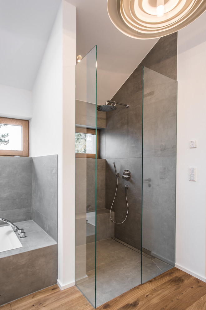 На фото: ванная комната среднего размера в современном стиле с душем без бортиков, серой плиткой, белыми стенами, паркетным полом среднего тона, душевой кабиной, коричневым полом и открытым душем