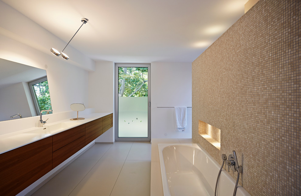 Immagine di una grande stanza da bagno design con lavabo integrato, ante lisce, ante in legno bruno, vasca da incasso, piastrelle marroni, piastrelle a mosaico e pareti bianche
