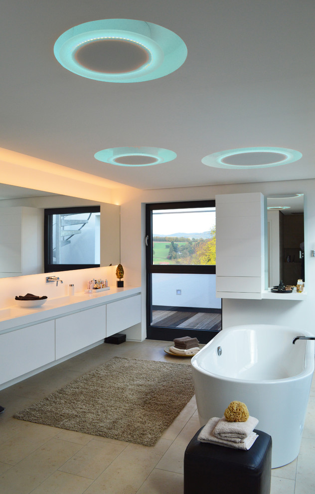 Bild på ett stort funkis badrum, med släta luckor, vita skåp, ett fristående badkar, vita väggar och ett integrerad handfat
