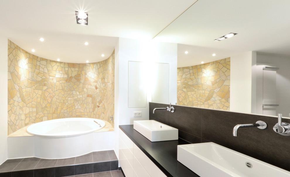 Diseño de cuarto de baño contemporáneo grande con lavabo sobreencimera, armarios con paneles lisos, puertas de armario blancas, jacuzzi, baldosas y/o azulejos beige, baldosas y/o azulejos de piedra y paredes blancas