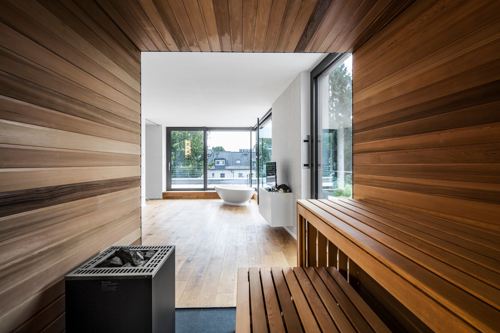 Diseño de sauna contemporánea extra grande con bañera exenta, paredes blancas y suelo de madera en tonos medios
