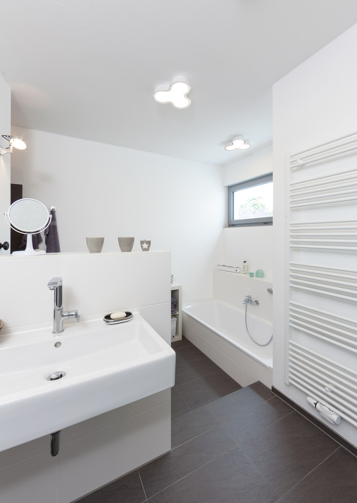 На фото: большая ванная комната в современном стиле с ванной в нише, серой плиткой, белой плиткой, белыми стенами, подвесной раковиной, керамической плиткой и полом из сланца с