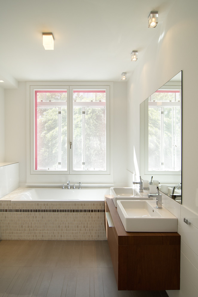 Immagine di una stanza da bagno design di medie dimensioni con ante lisce, ante in legno bruno, vasca da incasso, piastrelle beige, piastrelle marroni, piastrelle a mosaico, pareti bianche, lavabo a bacinella e top in legno