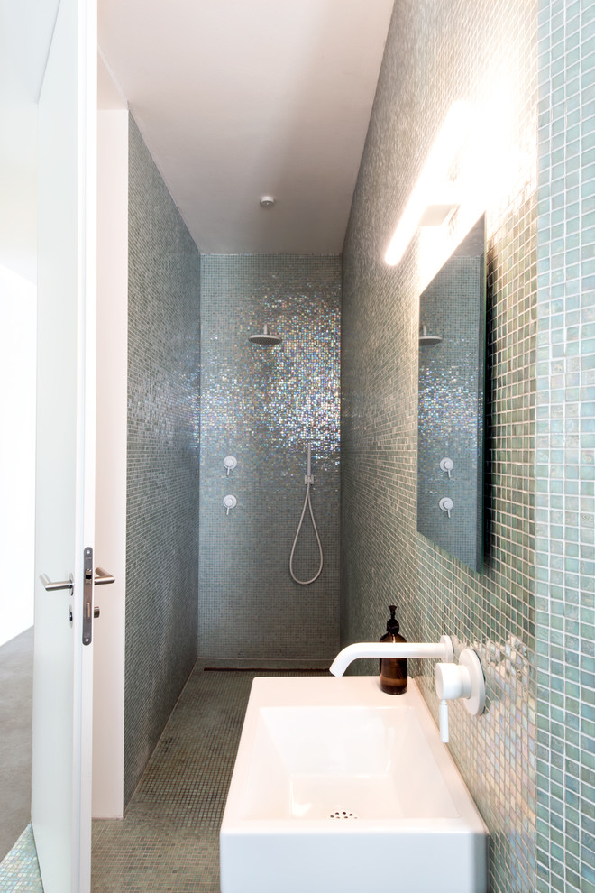 Ejemplo de cuarto de baño moderno pequeño con ducha a ras de suelo, sanitario de pared, baldosas y/o azulejos verdes, baldosas y/o azulejos en mosaico, paredes verdes, suelo con mosaicos de baldosas, aseo y ducha y lavabo tipo consola