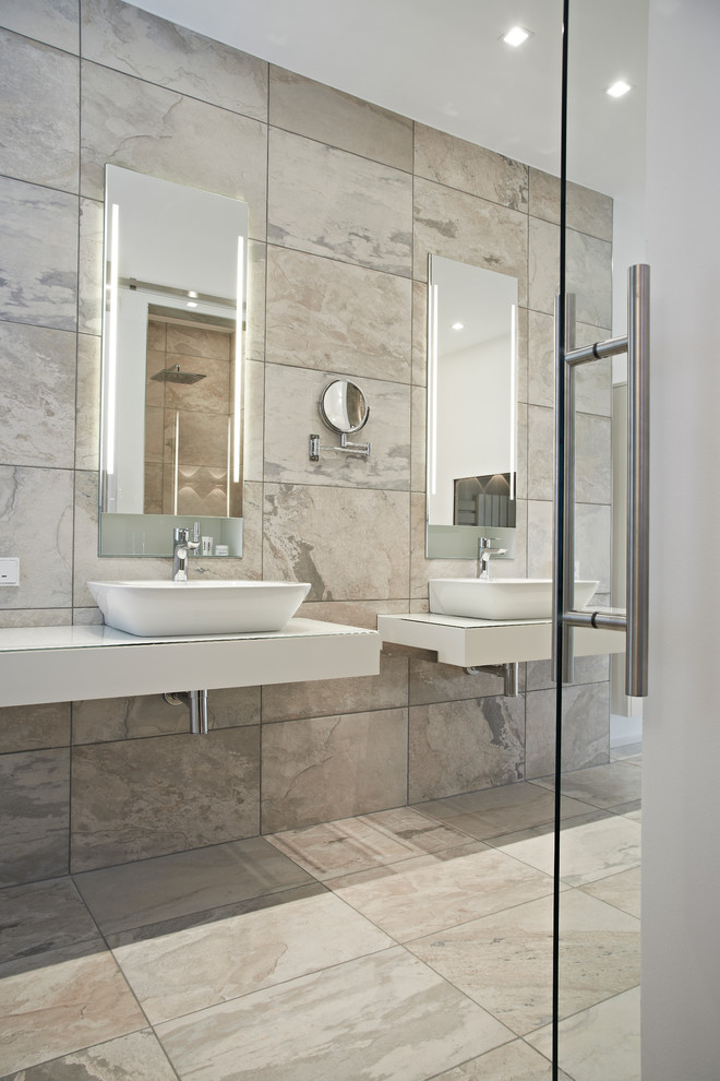 Источник вдохновения для домашнего уюта: ванная комната в современном стиле с настольной раковиной, серой плиткой и зеркалом с подсветкой