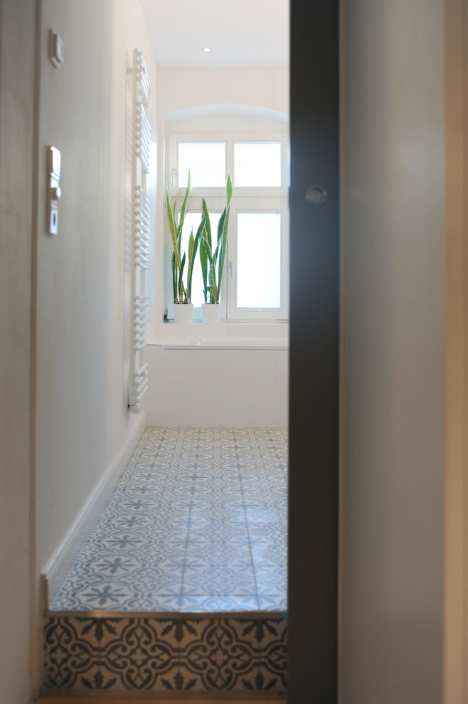 Idées déco pour une salle de bain contemporaine de taille moyenne avec une baignoire posée, une douche à l'italienne, WC suspendus, un carrelage blanc, des carreaux de porcelaine, un mur blanc, carreaux de ciment au sol, un lavabo suspendu et un sol gris.