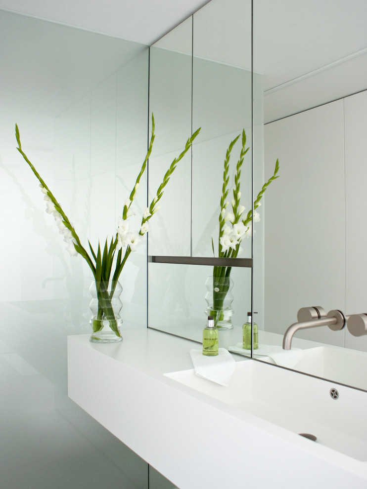 Esempio di una stanza da bagno con doccia design con pareti bianche, top in superficie solida, doccia a filo pavimento, pavimento in cemento e lavabo sospeso