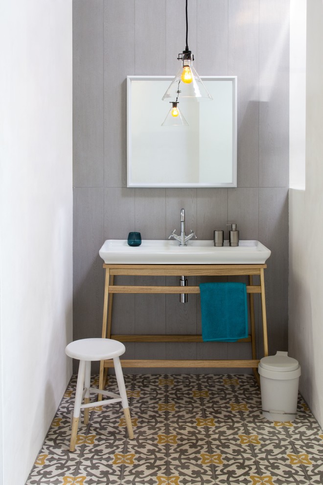 Aménagement d'une salle de bain contemporaine avec un carrelage gris, un mur blanc, carreaux de ciment au sol, une vasque, un plan de toilette en bois et un sol gris.