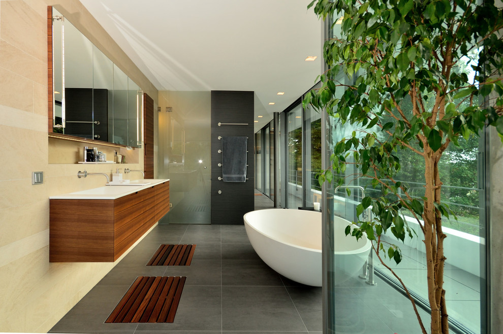 Idée de décoration pour une grande douche en alcôve design en bois foncé avec un placard à porte plane, une baignoire indépendante, un carrelage beige, un carrelage de pierre, un sol en ardoise et un lavabo intégré.