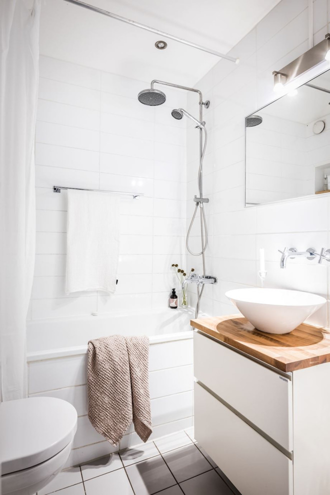 Modern inredning av ett litet beige beige badrum med dusch, med släta luckor, vita skåp, ett fristående badkar, en dusch i en alkov, vit kakel, porslinskakel, klinkergolv i porslin, ett fristående handfat, träbänkskiva, grått golv och dusch med duschdraperi