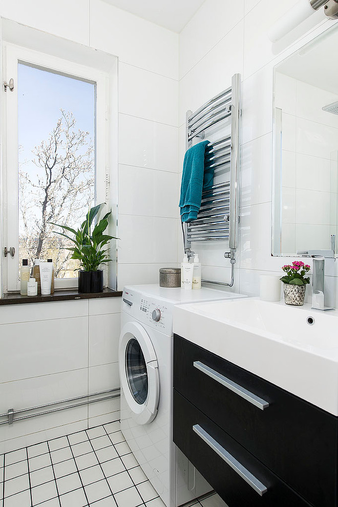 На фото: ванная комната со стиральной машиной в современном стиле с плоскими фасадами, черными фасадами, белой плиткой, белыми стенами, консольной раковиной, керамической плиткой и мраморным полом с