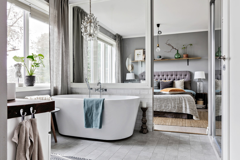 На фото: главная ванная комната среднего размера в стиле неоклассика (современная классика) с отдельно стоящей ванной, белой плиткой, серым полом и плиткой кабанчик с