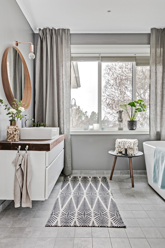 Idee per una stanza da bagno tradizionale di medie dimensioni con ante lisce, ante bianche, pareti grigie, lavabo a bacinella e top in legno