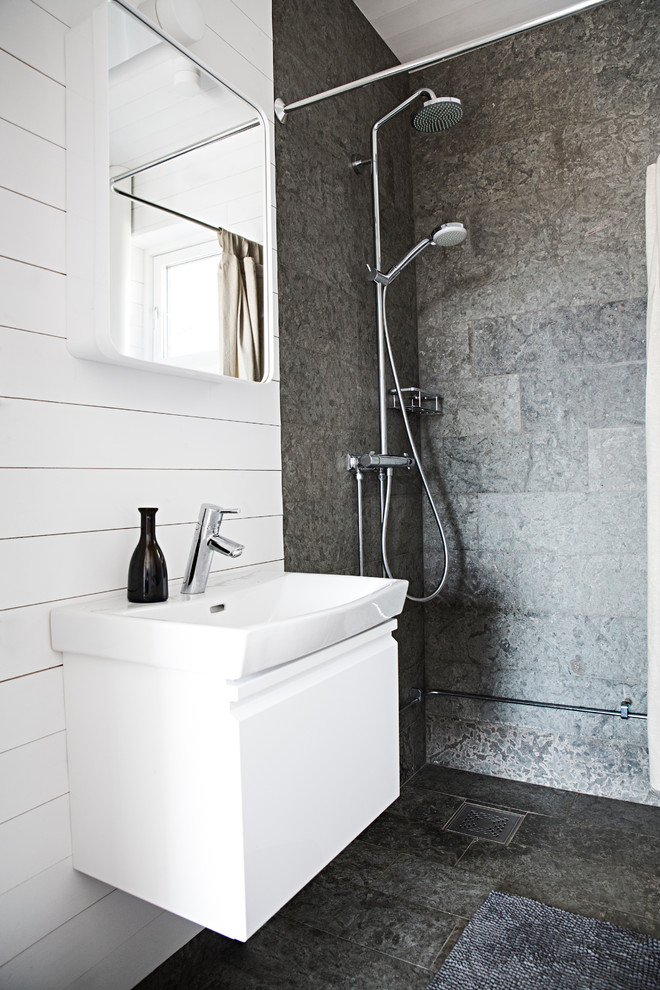 Foto på ett mellanstort skandinaviskt badrum med dusch, med släta luckor, vita skåp, en hörndusch, stenkakel, vita väggar, kalkstensgolv, ett integrerad handfat och kaklad bänkskiva