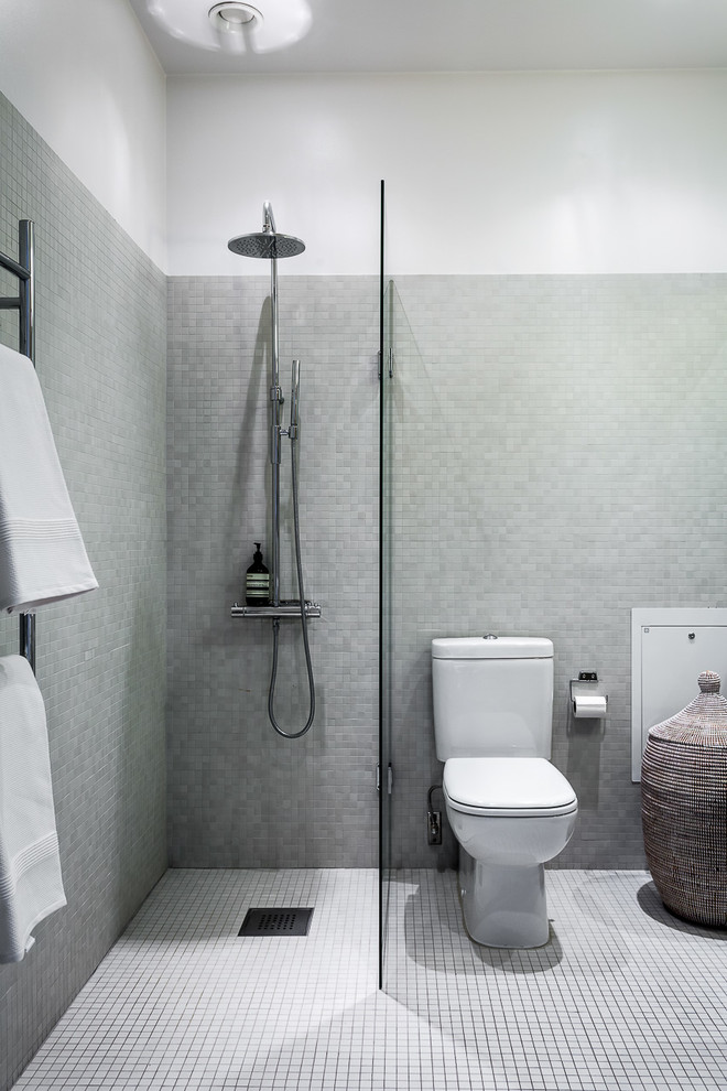 Immagine di una stanza da bagno con doccia moderna di medie dimensioni con doccia ad angolo, WC monopezzo, piastrelle grigie e pavimento con piastrelle a mosaico