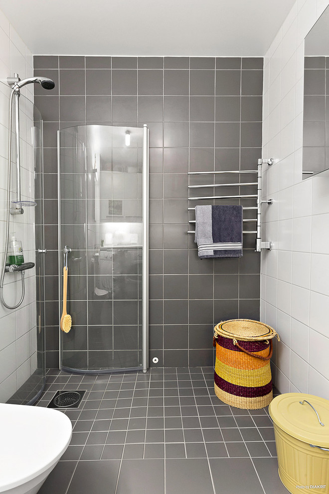Imagen de cuarto de baño moderno con ducha esquinera, baldosas y/o azulejos grises, paredes blancas y aseo y ducha