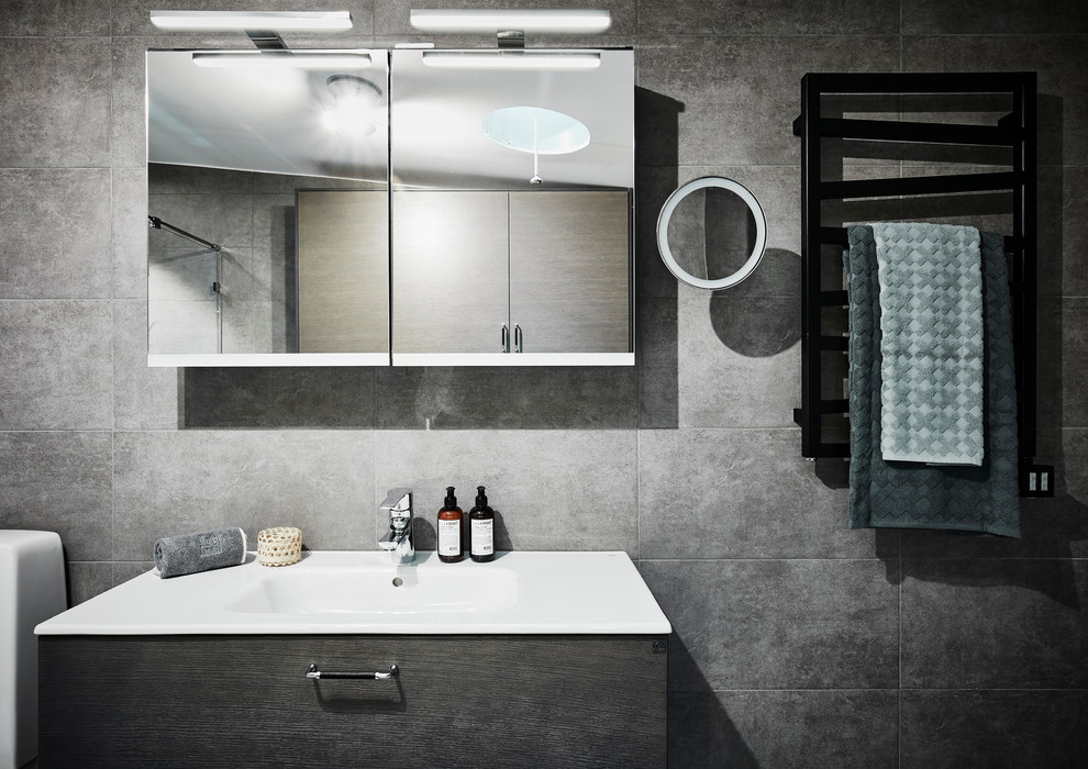 Immagine di una stanza da bagno con doccia design di medie dimensioni con ante lisce, ante in legno scuro, WC monopezzo, piastrelle grigie, piastrelle in ceramica, pavimento con piastrelle in ceramica, lavabo rettangolare e top in laminato