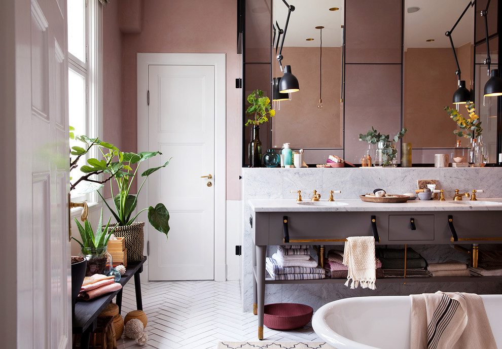 Inspiration pour une grande salle de bain principale design avec des portes de placard grises, un carrelage blanc, un mur rose, un sol en carrelage de céramique, un plan de toilette en marbre, un lavabo encastré et un placard à porte plane.